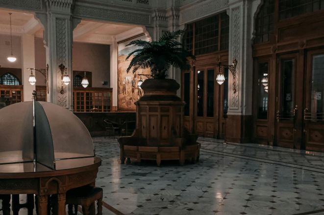 Elegant bank lobby with vintage decor and newspaper on table.