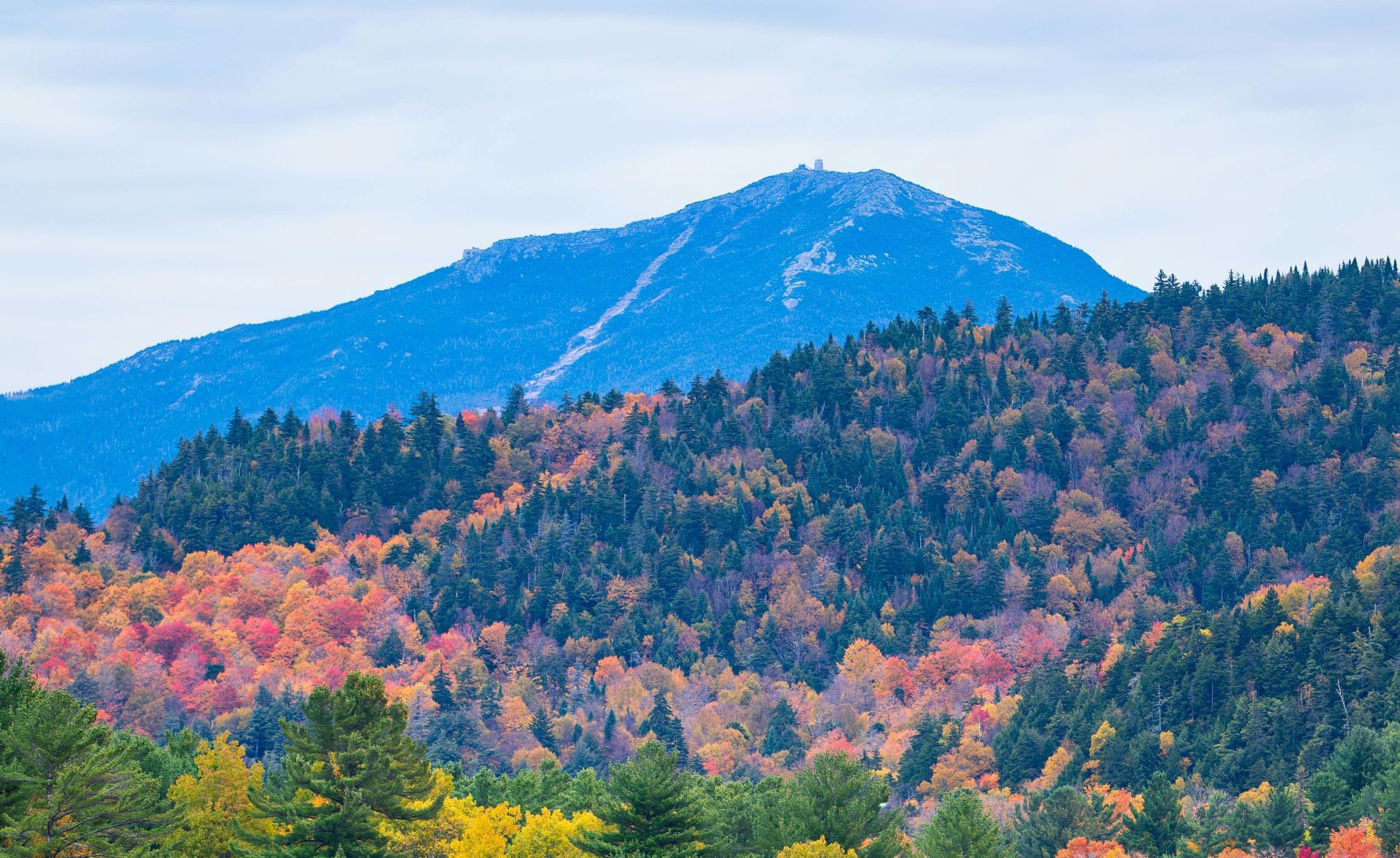 A beautiful autumn landscape of Mirror Lake, surrounded by vibrant fall foliage in the Adirondacks.