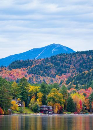 A beautiful autumn landscape of Mirror Lake, surrounded by vibrant fall foliage in the Adirondacks.